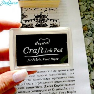 May include: A black ink pad with a clear plastic case. The ink pad is labeled "Crystal Craft Ink Pad for Fabric. Wood. Paper".