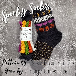 May include: A dark grey knitted sock with a Halloween pattern of ghosts, pumpkins, and bats, alongside a colourful yarn set labelled "Spooky Socks Set". The image includes the text "Spooky Socks", "Pattern by: Rosie Posie Knit Co", and "Yarn by: Indigo Guinea Fiber".