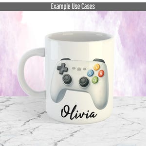 May include: White ceramic mug with a video game controller design. The controller has black joysticks and coloured buttons. The name "Olivia" is written in cursive below the controller. The top of the mug has the text "Example Use Cases".
