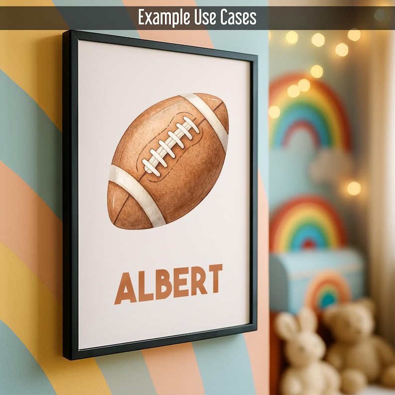 May include: A framed print with a watercolour illustration of a brown American football, white laces and stripes. The name "ALBERT" is printed in brown below the football. The frame is black, and the background is a light colour.