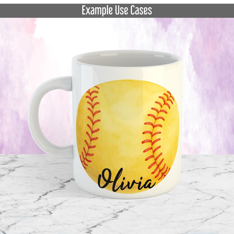 May include: White ceramic mug with a yellow softball design, red stitching, and the name "Olivia" in black script. The mug has a curved handle. The background is a marble surface.