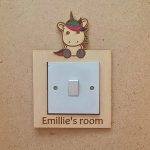 May include: A wooden light switch cover with a unicorn cutout and the text "Emillie's room".