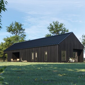 May include: A modern, black-clad house with a dark metal roof sits on a grassy lawn. The house has a simple, rectangular design with large windows and a covered porch area. Trees and a blue sky provide a natural backdrop.