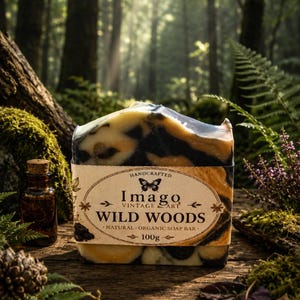 May include: A handcrafted soap bar with a Wild Woods theme, featuring a blend of black, yellow, and brown colours. The label reads "Imago Vintage Art" and "Natural Organic Soap Bar - 100g". The soap is set against a forest backdrop.