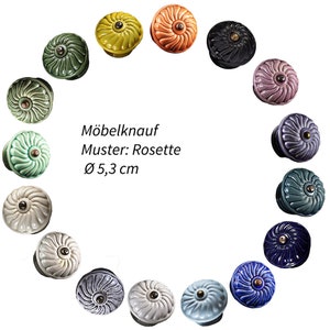 Peut inclure: Un ensemble de 15 boutons de meuble en céramique de différentes couleurs, chacun avec un motif en rosette et un diamètre de 5,3 cm. Les boutons sont disposés en cercle sur un fond blanc. Le texte "Möbelknauf Muster: Rosette Ø 5,3 cm" est écrit au centre du cercle.