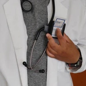 May include: A white doctor's coat with a stethoscope and a white ID badge hanging from the neck.
