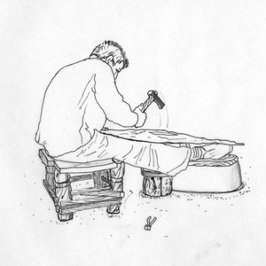 Peut inclure: Une personne assise sur un tabouret, utilisant un marteau pour travailler sur un morceau de bois. La personne porte une chemise à manches longues et un pantalon. Le bois repose sur un tonneau.