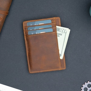May include: A brown leather wallet with three credit cards and a twenty dollar bill inside.