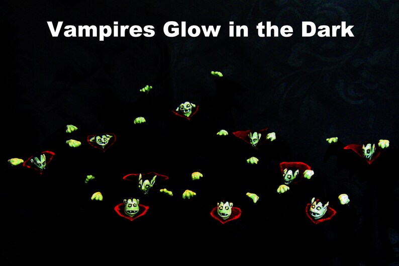 May include: A group of green glowing vampire figures with red capes against a black background. The text "Vampires Glow in the Dark" is at the top of the image.