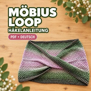 Può includere: Un modello di uncinetto in PDF intitolato MÖBIUS LOOP HÄKELANLEITUNG che mostra una sciarpa infinita sfumata con un design attorcigliato. La sciarpa passa dal verde scuro al rosa chiaro al verde scuro con un motivo a punto traforato.