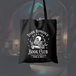 May include: Black tote bag with white text and graphics. The design includes the words "Dark Romance Readers Book Club" with a skull, books, and a rose. The text "I prefer my fairytales - dark & spicy -" is also included.