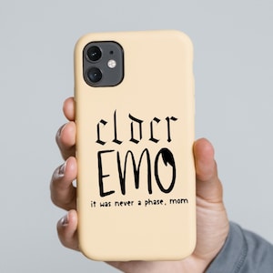 May include: A beige phone case with a black design that says "cloer EMO it was never a phase, mom".