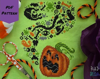 May include: A cross-stitch pattern on green fabric featuring a Halloween design. The design includes a jack-o'-lantern, a snake-like shape with Halloween icons, and the text "PDF PATTERN". Decorative elements include scissors and candy corn.