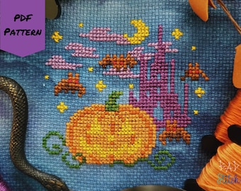 May include: Cross-stitch pattern featuring a Halloween theme. The design includes a large orange pumpkin, bats, a purple castle, a yellow moon, and stars against a blue background. The words "PDF PATTERN" are in a purple banner.