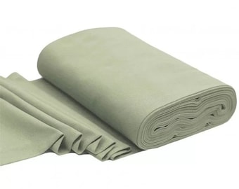 Puede incluir: Un rollo de tela verde salvia, parcialmente desenrollado para mostrar la textura y los pliegues. La tela parece suave y es adecuada para proyectos de costura. El fondo es blanco.