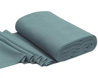 Puede incluir: Un rollo de tela azul turquesa. La tela está doblada y enrollada, mostrando su textura suave.