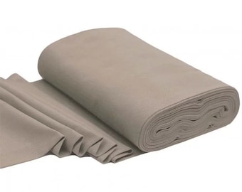 May include: A roll of light brown fabric. The fabric is folded and rolled up, showing the texture of the material.