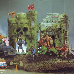 May include: A green plastic castle playset with a skull-shaped entrance, featuring multiple figures from the Masters of the Universe toy line. The set includes a green dragon, a ladder, and a small vehicle. The text "Masters of the Universe" and "The most powerful toys ever to invade this planet." is printed on the bottom of the image.