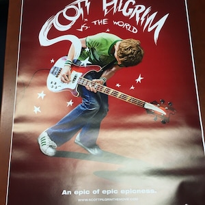May include: A movie poster for "Scott Pilgrim vs. The World" with a red background. The poster features a person playing a bass guitar, with the title in white stylized text. The text "COMING SOON" is at the bottom.