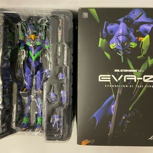 May include: A Real Action Heroes Neo Evangelion-01 Test Type action figure in a plastic display case. The figure is green, purple, and black. The box art features a close-up of the figure's head and the text "REAL ACTION HEROES NEO EVA-01 EVANGELION-01 TEST TYPE" and "EVANGELION 2.0 YOU CAN (NOT) ADVANCE".
