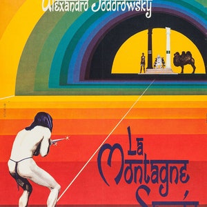 May include: A vintage movie poster for "La Montagne Sacrée" by Alexandre Jodorowsky. The poster features a nude figure aiming a weapon, with text in French. The background has a rainbow arch and a red and orange gradient.