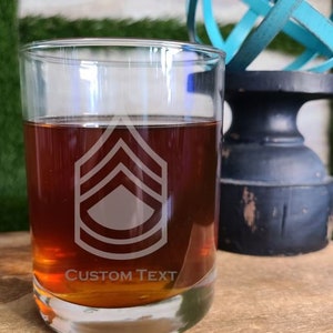May include: A clear glass with a brown liquid inside. The glass has a custom design etched into it, featuring a military rank insignia and the text "CUSTOM TEXT".