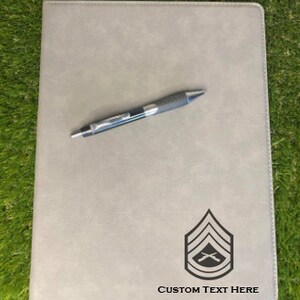 May include: A gray leatherette folder with a black military rank insignia and the text "CUSTOM TEXT HERE".