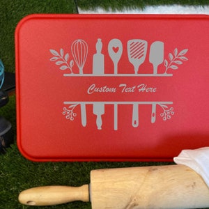 May include: Red baking pan with a white design of kitchen utensils and the text "Custom Text Here".