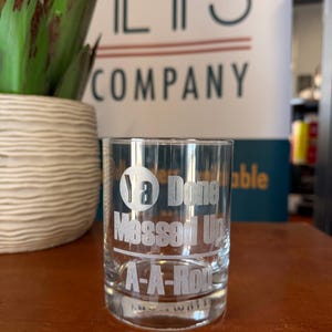 May include: A clear glass tumbler featuring white etched text that reads Ya Done Messed Up A-A-Ron. The glass has a cylindrical shape with a thick base and smooth walls, displaying the engraved lettering clearly against the transparent surface.
