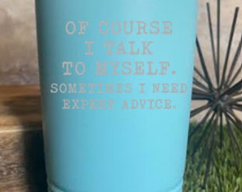 May include: A teal insulated tumbler with a silver rim and lid. The tumbler has the text "OF COURSE I TALK TO MYSELF. SOMETIMES I NEED EXPERT ADVICE." in a light pink font. The tumbler is cylindrical and sits on a bed of green grass.