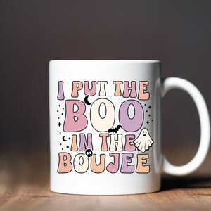 Puede incluir: Taza de caf&eacute; de cer&aacute;mica blanca con un dise&ntilde;o rosa, morado y naranja. La taza dice "I put the BOO in the BOUJEE".