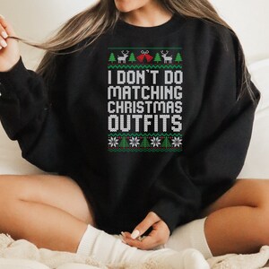 May include: Black Christmas sweater with a white design that says "I don't do matching Christmas outfits".