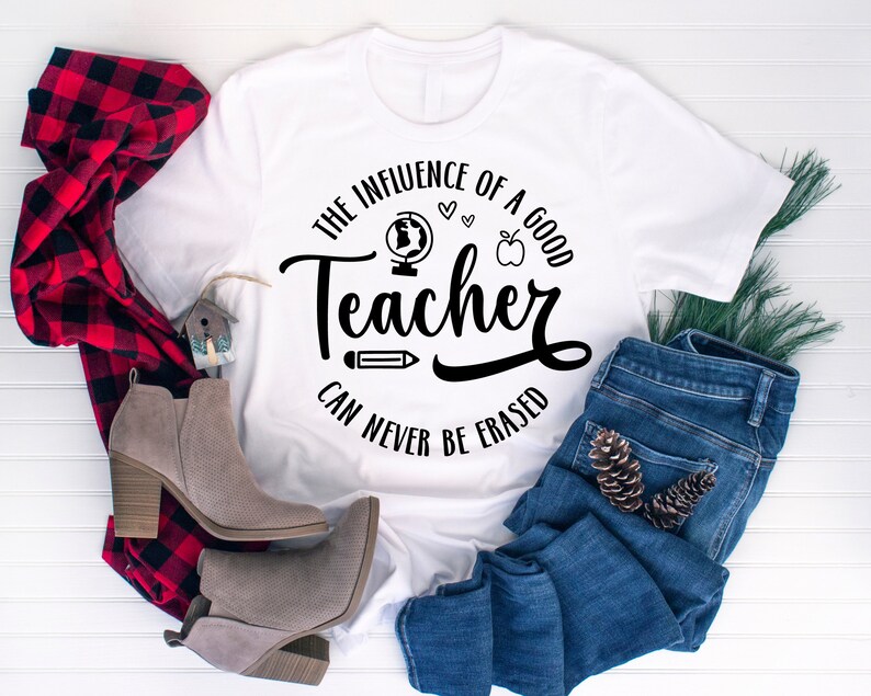 May include: White t-shirt with a black graphic that says "The influence of a good teacher can never be erased". The graphic includes a globe, apple, pencil, and hearts.