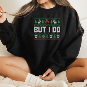 May include: Black Christmas sweater with a green, white, and red pattern. The sweater has a reindeer, a Christmas tree, and the words "But I Do" on it.