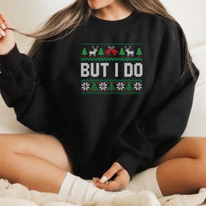 May include: Black Christmas sweater with a green, white, and red pattern. The sweater has a reindeer, a Christmas tree, and the words "But I Do" on it.