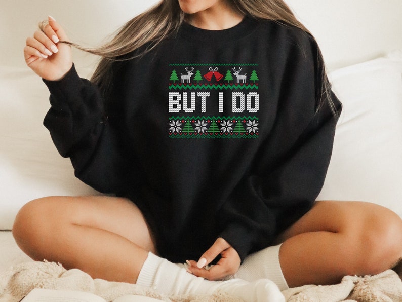 May include: Black Christmas sweater with a green, white, and red pattern. The sweater has a reindeer, a Christmas tree, and the words "But I Do" on it.