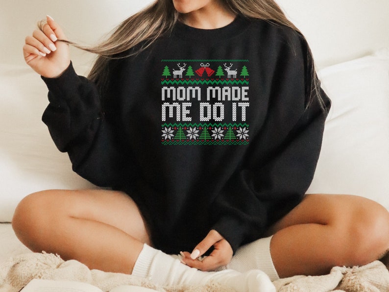 May include: Black Christmas sweater with a green, white, and red design. The sweater has the text "Mom Made Me Do It" in white.