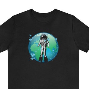 May include: A black t-shirt with a graphic of an astronaut wearing scuba gear and diving into a blue and green Earth.