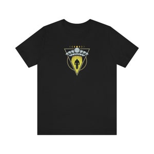 May include: Black t-shirt with a graphic of a UFO hovering over a person in a triangle with a yellow glow and a circle around it.