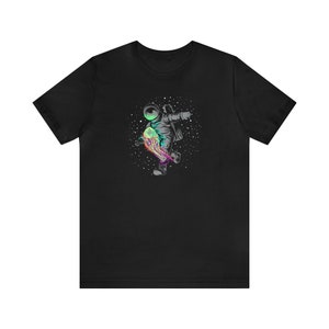May include: Black t-shirt with a graphic of an astronaut riding a colorful, glowing skateboard in space.