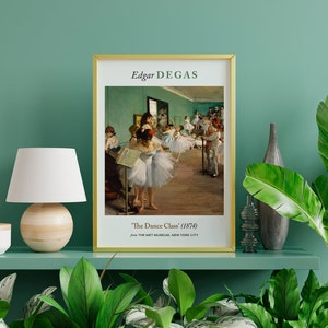 Pu&ograve; includere: Una stampa incorniciata di un dipinto di Edgar Degas intitolato "The Dance Class" (1874). Il dipinto raffigura un gruppo di ballerine in uno studio di danza, con una parete verde e un pavimento in legno.