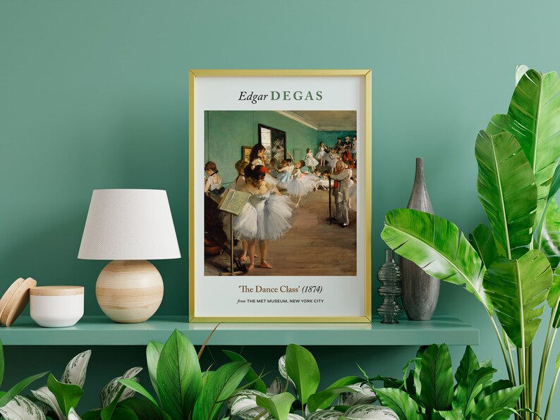 Pu&ograve; includere: Una stampa incorniciata di un dipinto di Edgar Degas intitolato "The Dance Class" (1874). Il dipinto raffigura un gruppo di ballerine in uno studio di danza, con una parete verde e un pavimento in legno.