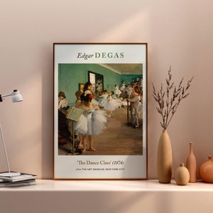 Pu&ograve; includere: Una stampa incorniciata di un dipinto di Edgar Degas intitolato "La Classe di Danza" (1874). Il dipinto raffigura un gruppo di giovani ballerine in uno studio di danza, con una parete verde e un pavimento in legno.
