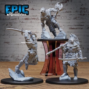 May include: Three gray, detailed, miniature figures of warriors with animalistic features. The figures are posed in dynamic stances, holding weapons such as swords and spears. The figures are displayed on circular bases.