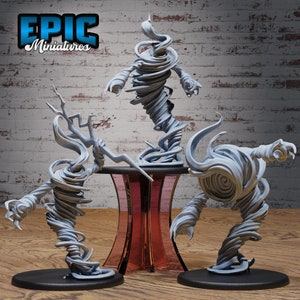 May include: Three gray, swirling, miniature sculptures of tornadoes on black bases. The sculptures are arranged on a red and black pedestal. The text "EPIC Miniatures" is visible in the top left corner of the image.