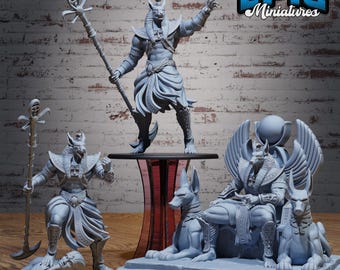 May include: A collection of gray miniature statues depicting Egyptian deities. The statues include figures of Anubis, some holding staffs, and others seated on thrones. The Epic Miniatures logo is visible in the upper right corner.