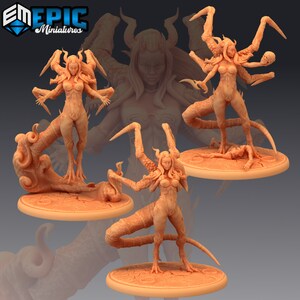 以下が含まれることがあります： 複数の腕と尻尾を持つ女性悪魔の3Dプリントミニチュアフィギュア3体。フィギュアは薄い茶色に塗られており、それぞれ異なるポーズをとっている。