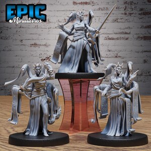 Puede incluir: Tres miniaturas de resina gris para juegos de mesa que representan figuras élficas con túnicas fluidas. Cada figura presenta orejas puntiagudas, cuernos y largos pergaminos con runas grabadas. Una figura sostiene una espada y otras posan.