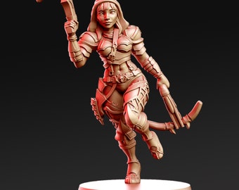 May include: A miniature figurine of a female warrior wearing armor and a hooded cloak, holding a crossbow in her right hand. The figurine is painted in a reddish-brown color and is standing on a circular base.