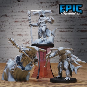 May include: Three gray painted miniature figurines of hammerhead shark people. The figures are posed in a dynamic fashion, holding weapons and standing on bases. The figures are labeled "EPIC Miniatures".
